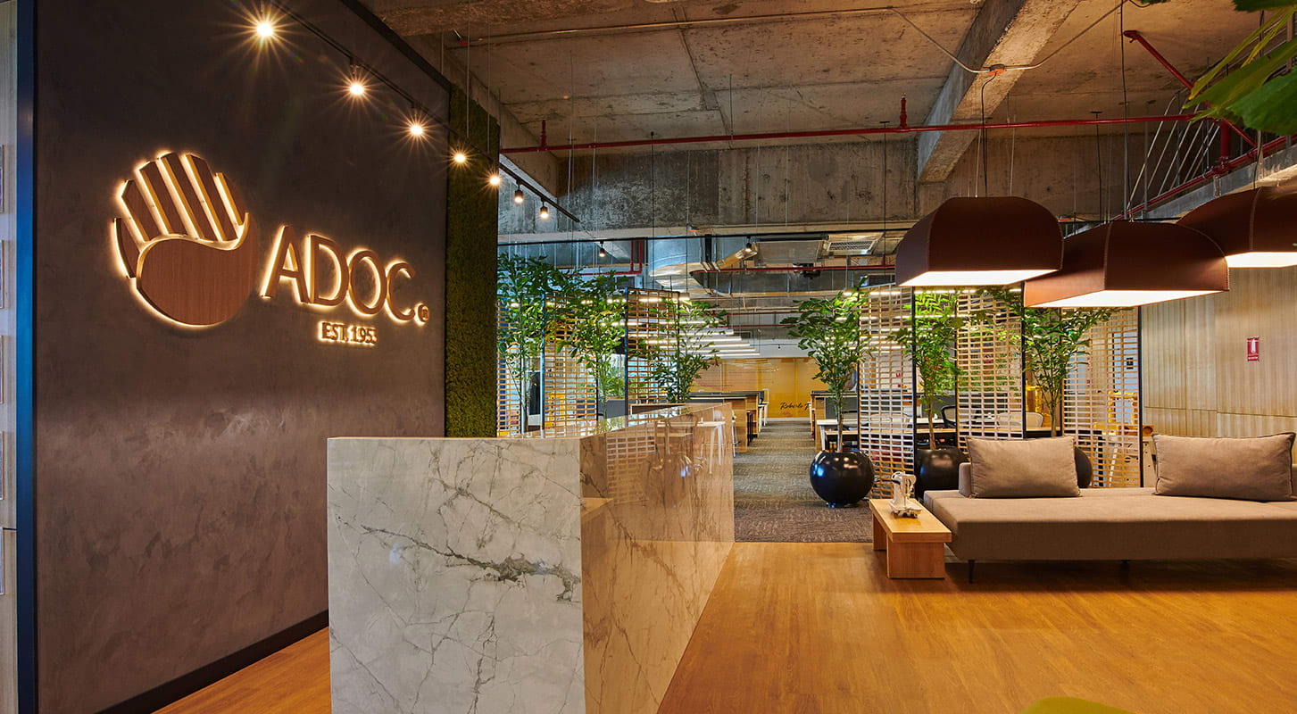 Image of ADOC elegant office space featuring a large ADOC logo on the back wall and seating area.